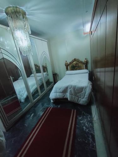 a bedroom with two beds and two mirrors at شقق Hs 4 in Cairo