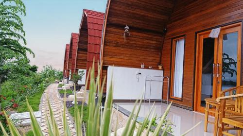 a wooden house with a pool in front of it at Kubuhill Sunset Bungalow in Nusa Penida