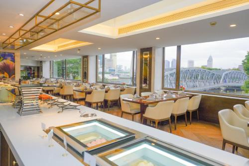 a restaurant with a view of a bridge at Broadway Mansions Hotel - On the Bund - Journey Through Time Old Shanghai Republic Dreams in Shanghai
