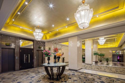 a lobby with a table in the middle of a building at Broadway Mansions Hotel - On the Bund - Journey Through Time Old Shanghai Republic Dreams in Shanghai