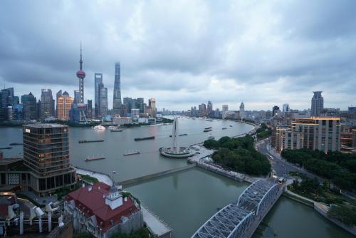 a view of a river with a city in the background at Broadway Mansions Hotel - On the Bund - Journey Through Time Old Shanghai Republic Dreams in Shanghai