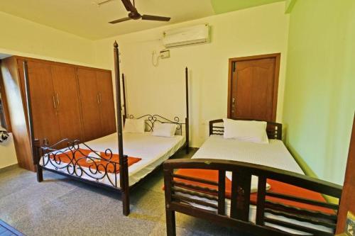 a bedroom with two beds and a bench in it at Villa close to Rock beach-Family Room in Puducherry
