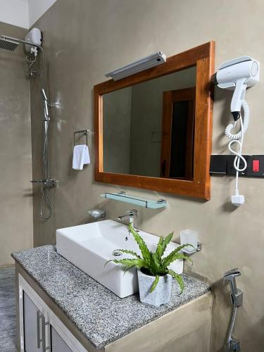 a bathroom with a white sink and a mirror at Sunset Bay in Dickwella