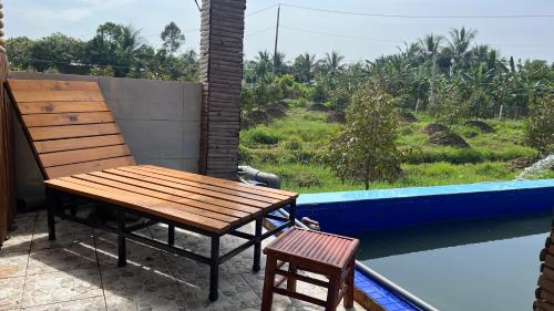 a wooden bench and a chair sitting on a balcony at Can Tho Farmstay in Cái Răng