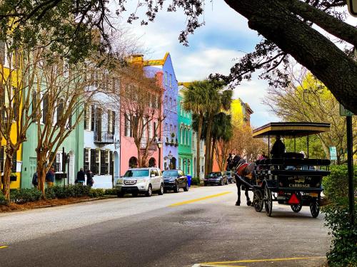 a horse drawn carriage on a city street with buildings at OG23: 23 Ocean Green in Kiawah Island
