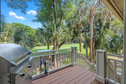 a balcony with a grill and palm trees at OG23: 23 Ocean Green in Kiawah Island
