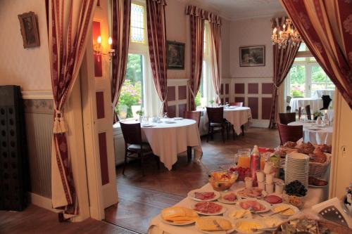 ein Esszimmer mit einem Tisch und Teller mit Lebensmitteln in der Unterkunft Hotel Huys ter Schelde in Koudekerke