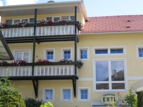 a building with a balcony with flowers on it at Pension & Apartments Ertl in Seeboden