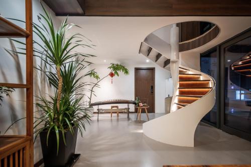 a spiral staircase in a room with plants at 清澜居 东方唐韵民宿酒店 in Xi'an