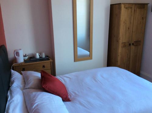 a bedroom with a white bed and a mirror at River Lodge B&B Ltd in Spalding