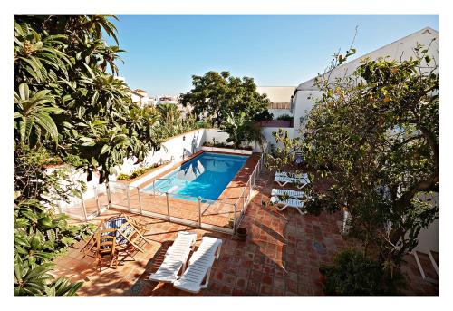 een uitzicht over het zwembad met ligstoelen bij Hostal La Posada in Conil de la Frontera