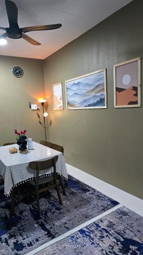 a dining room with a table and a ceiling fan at Humaira Homestay Teluk Intan in Teluk Intan