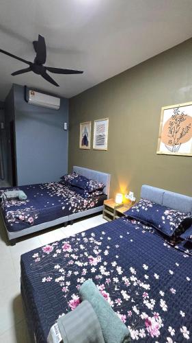 a bedroom with two beds and a ceiling fan at Humaira Homestay Teluk Intan in Teluk Intan