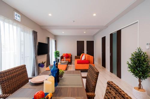 a dining room with a table and a living room at Coldio Joint Home Naha in Naha