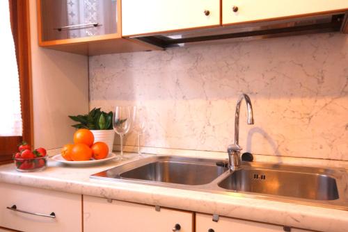 een keuken met een gootsteen en een bord met sinaasappels bij Tiepolo in Venetië