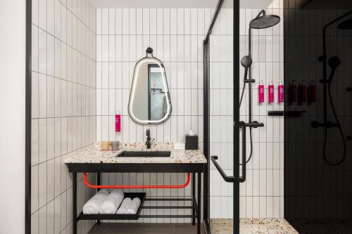 a bathroom with a sink and a mirror at Moxy Suzhou City Centre in Suzhou