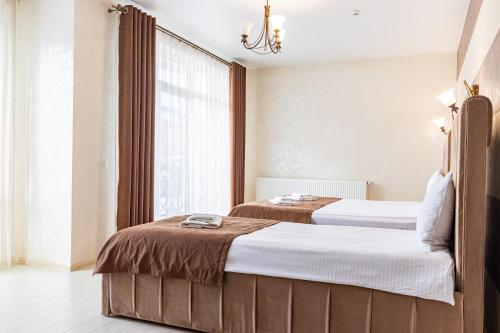 two beds in a room with a window at Gold Palace SPA Resort Bukovel in Bukovel