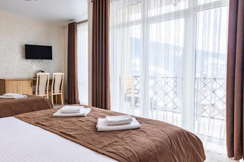 a hotel room with two beds and a large window at Gold Palace SPA Resort Bukovel in Bukovel