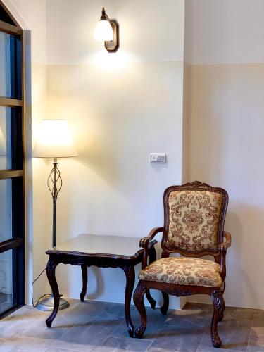 a chair sitting next to a table and a lamp at Villa San Diego in Puli