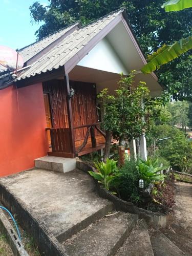a small house with a red wall at Saen Kam Resort in Chiang Mai