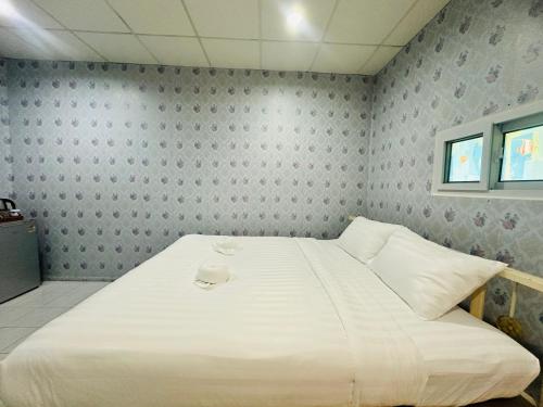 a bedroom with a large white bed in it at Navy Guesthouse in Ban Laem Sai