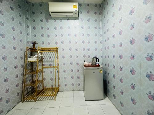 a kitchen with a refrigerator and a wall at Navy Guesthouse in Ban Laem Sai