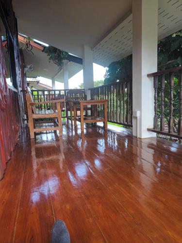 a room with wooden tables and chairs on a balcony at Saen Kam Resort in Chiang Mai