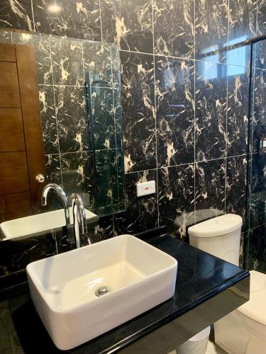 a bathroom with a sink and a toilet at Villa San Diego in Puli