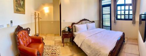 a bedroom with a bed and a chair at Villa San Diego in Puli