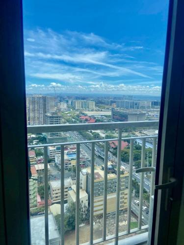 a view of a city from a window at La Chicka Staycation in Coast Residences in Manila
