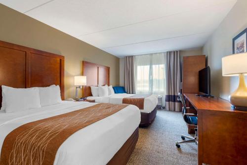 a hotel room with two beds and a desk at Comfort Inn & Suites Wilkes Barre - Arena in Wilkes-Barre