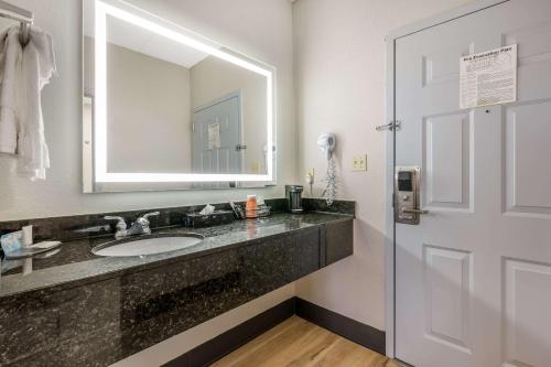 a bathroom with a sink and a mirror at Clarion Pointe Louisville East in Louisville
