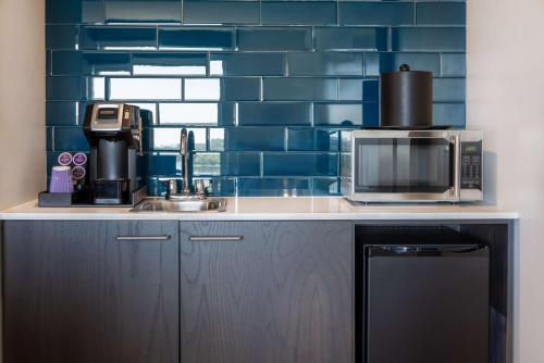 a kitchen with a sink and a microwave at Hilton Garden Inn Fredericton in Fredericton