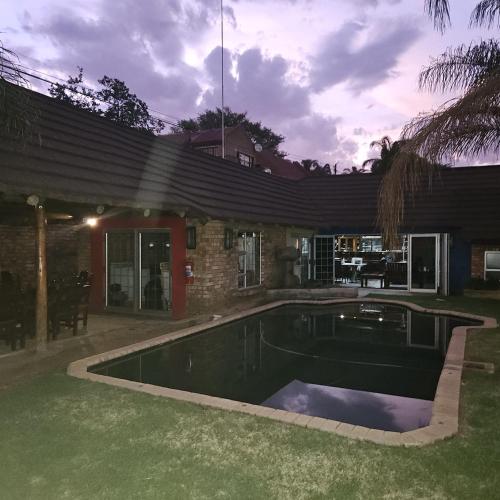 a swimming pool in front of a house at Da Vinci Palms in Witbank