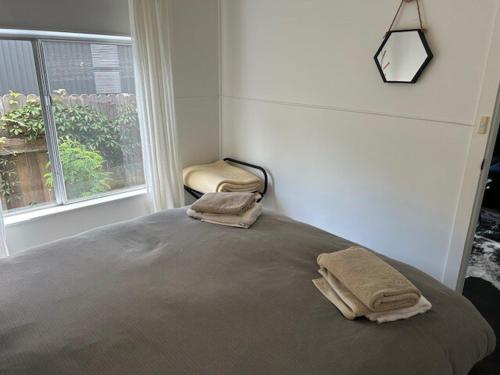Un dormitorio con una cama con dos toallas encima. en Maisie's Cottage, en Mount Victoria