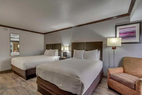 a hotel room with two beds and a chair at Park Inn by Radisson, Salt Lake City-Midvale in Midvale