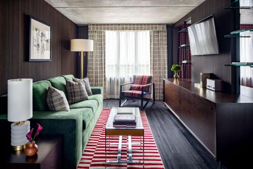 a living room with a green couch and a table at Graduate by Hilton Columbus in Columbus