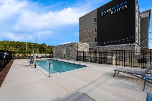 a swimming pool in front of a building at Everhome Suites Fayetteville near Fort Bragg in Fayetteville
