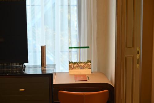 a desk with a window and a desk with a chair at The Townhouse Hotel - Small Luxury Hotels of the World in Islamabad