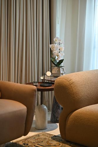 a living room with a table with a vase of flowers at The Townhouse Hotel - Small Luxury Hotels of the World in Islamabad