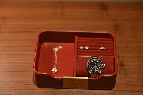 a watch in a red box on a wooden table at The Townhouse Hotel - Small Luxury Hotels of the World in Islamabad