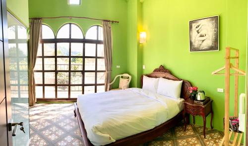 a bedroom with a bed in a green room at Villa San Diego in Puli