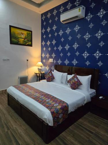 ein Schlafzimmer mit einem großen Bett und einer blauen Wand in der Unterkunft The Marker in Tehla