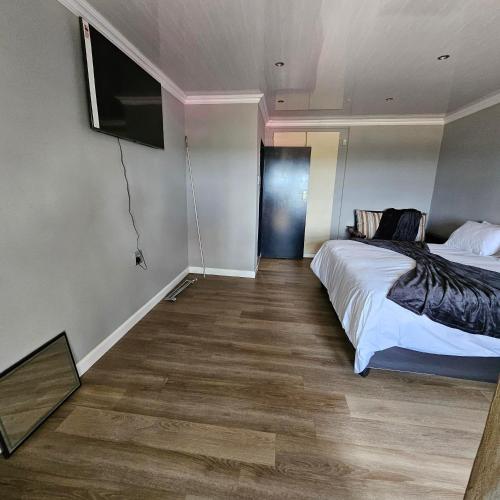 a bedroom with a bed and a flat screen tv at Da Vinci Palms in Witbank