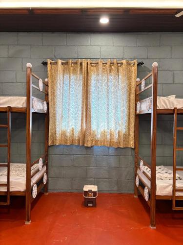 a room with three bunk beds and a window at Mowgli's Cafe Hampi & Guest House in Hampi