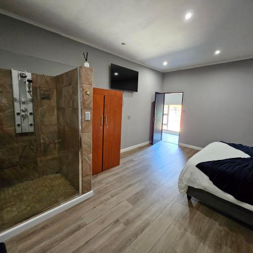a bedroom with a shower and a bed in it at Da Vinci Palms in Witbank