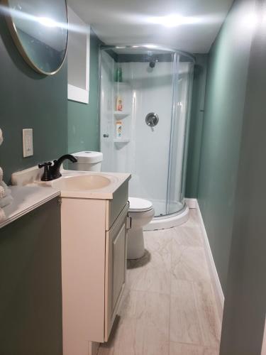 a bathroom with a sink and a toilet and a shower at Spacious Basement Apartment near metro downtown Washington DC in Capitol Heights