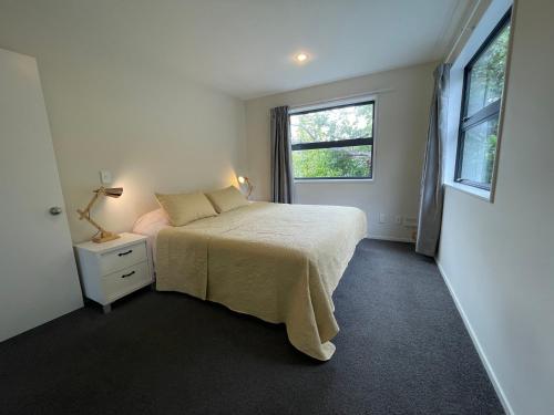 a white bedroom with a bed and a window at Character & new CNZhouse with quiet in Christchurch