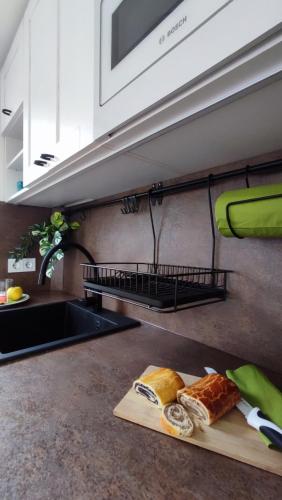 a kitchen with a counter with bread on a cutting board at Panoráma Nyaraló in Tahitótfalu