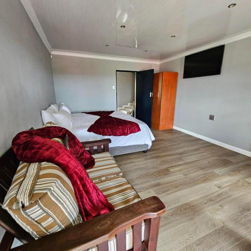a room with two beds and a bench in it at Da Vinci Palms in Witbank